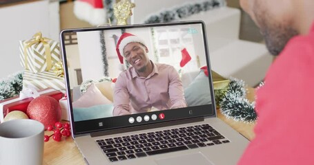 Wall Mural - African american man with christmas decorations having video call with african american man