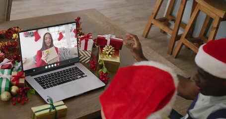 Poster - Diverse couple with santa hats having laptop video call with biracial woman