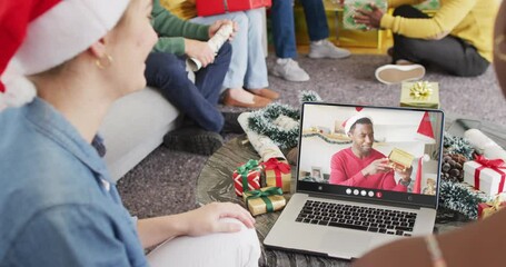 Poster - Animation of diverse friends in santa hats on laptop video call with man at christmas