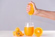 woman's hand squeezing and squeezing half orange