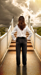 Wall Mural - Rear view of an Asian businesswoman standing on the bridge