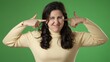 © Robert Peak - Unhappy irritated frustrated sad angry young brunette woman 20s years closed eyes cover ears do not want to listen scream isolated on green screen background studio portrait