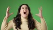 © Robert Peak - Angry frustrated despair upset with hands raised in air portrait of pretty woman 20s isolated isolated on green screen background.