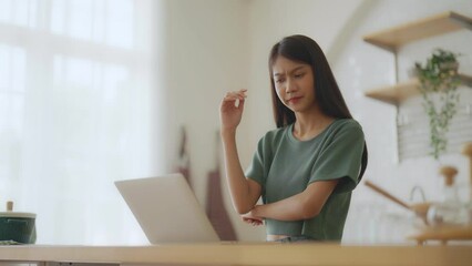 Poster - Smiling asian young woman working on laptop at home office. Young asian student using computer remote studying, virtual training, e-learning, watching online education webinar at house