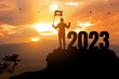 2023 New year Success concept.silhouette of businessman holding winner flag with 2022 on the mountain. success in the future goal and passing time.copy space.