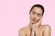 © Evrymmnt - Studio portrait of a young sensual woman with closed eyes touching her face. Female model posing over isolated pink background. Close up, copy space.