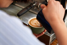 Young female barista preparing coffee with coffee machine