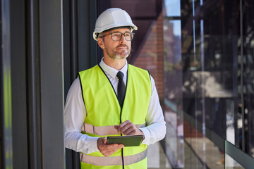 Construction, digital tablet and man with vision, thinking and planning at construction site. Construction worker, future and online app for creative, design and idea for engineering or architecture