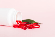 Red Pills Spilled Around A Pill Bottle. Medicines And Prescription Pills Flat Lay Background. Red Medical Capsules
