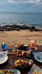 Wall Mural - Dinner table with Thai food and bbq fish on the beach of Pattaya Thailand.