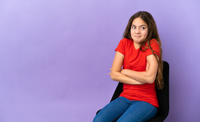 Canvas Print - Little caucasian girl sitting on a chair isolated on purple background making doubts gesture while lifting the shoulders