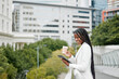 © Mia B/peopleimages.com - Black woman, digital tablet and coffee on a rooftop, work schedule and reading email while on break outdoor. Business woman, happy smile and funny online post or social media, morning and New york