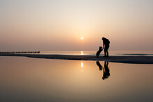 Mann Mit Hund Vor Sonnenuntergang Am Meer, Silhouette