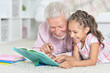 © aletia2011 - grandfather reading book with his little granddaughter