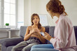 Psychologist listening to child. Professional therapist working with teenage child. Adolescent girl sitting on sofa and answering questions that school psychologist asks her. Therapy concept