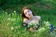 Young beautiful girl lies on the green grass. Girl enjoying summer day