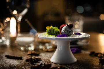 Vegan truffles dessert made of dates, almound and peanut butter on a plate. Delicious healthy food closeup served for lunch on a table in modern gourmet cuisine restaurant