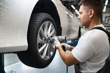 Male Changing Car Wheel In Tire Fitting