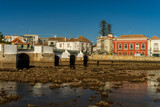 Fototapeta Fototapety do pokoju - Widok na najstarszy most na rzece Gilao w miasteczku Tavira, Portugalia. Fragment nabrzeża, piękny słoneczny dzień. 