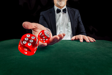 Gambling concept. Close up of male hand throwing dice at casino, gambling club. Сasino chips or Casino tokens, poker cards, gambling man spending time in games of chance