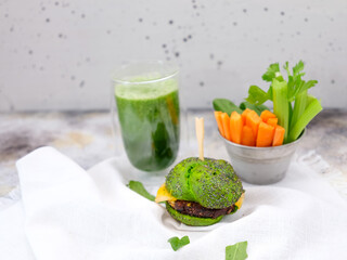 green delicious Burger with spinach smoothie on a concrete background