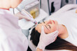 Leinwandbild Motiv Cosmetologist doing hydrafacial treatment on woman face