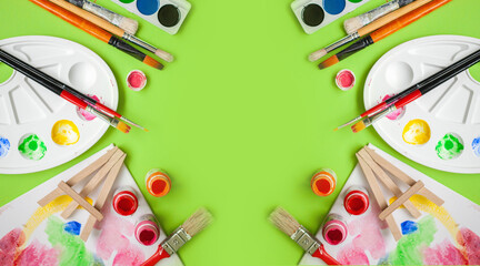 Wall Mural - 
a set of drawing supplies on a light green or green background. creative frame with copy space. top view. copy space.