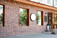 Cafe Exterior In Loft Style With Red Brick Wall, White Round Logo For Mockup Design