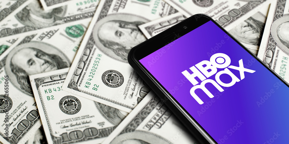 Hbo Max logo on smartphone screen on background of dollars. HBO Max is ...