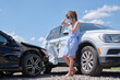 © bilanol - Sad female driver speaking on sellphone on street side calling for emergency service after car accident. Road safety and insurance concept