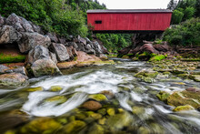 Historic Red Covered Bridge Over A Shallow Stream, Fundy National Park; Saint John, New Brunswick, Canada