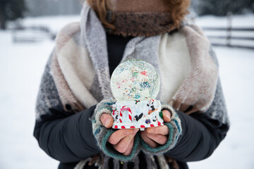 Sticker - woman holding Christmas decoration in snow