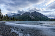 Surf Washing Up On A Rocky Shore On A Yukon Landscape At Sunset; Haines Junction, Yukon, Canada