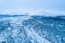 The South Klondike Highway Winds Its Way Through The Wintry Yukon Landscape With Forests And Snow-capped Mountain Peaks; Carcross, Yukon, Canada
