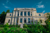 Fototapeta  - Front facade of national museum of bosnia and herzegovina on a summer day hiding behind some greenery.