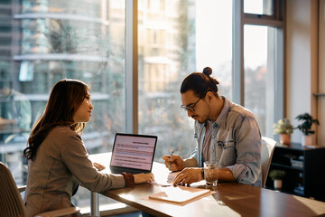 Wall Mural - Job candidate filling paperwork while having meeting with Asian businesswoman in office.