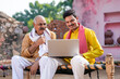 © Niks Ads - Young indian farmer showing some detail to his father in laptop.