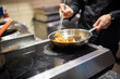© pavel siamionov - man chef cooking tasty shrimp in frying pan on kitchen