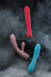© Vitaliy Scherbonos - Silicone sex toys in puffs of smoke on a black background Sexual Clitoris Massager for Women Erotic toy for fun Sex gadget and masturbation device Place for text Sex shop concept Dildo Vibrators