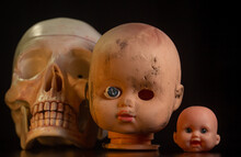 Damaged Dirty Doll Head And Skull On Black Background Isolated