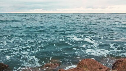 Wall Mural - Rocky sea coast beach in evening time. Ocean coast with waves and sunset sky