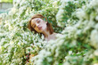 Young beautiful girl on a summer day among flowering trees