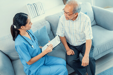 Wall Mural - A young female doctor inquires about personal information of a contented senior at home. Medical care for the elderly, elderly illness, and nursing homes, home care.