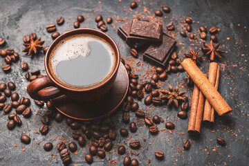 Wall Mural - Fresh brewed black coffee in a cup on dark background with coffee beans and chocolate pieces