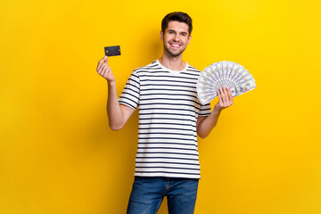 Poster - Portrait of positive nice person hands hold usd banknotes bill plastic debit card isolated on yellow color background