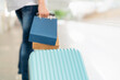 Close up on the luggage and man holding colorful shopping bag standing in the shopping central area. Enjoyment on shopping and happy with gift during end of the year. Mid year sale and sale concept