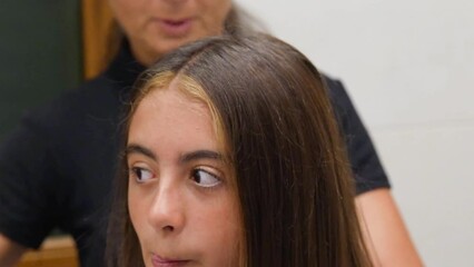 Canvas Print - Mom combs a child's hair in the bathroom at home