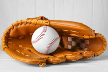 Leather Baseball Glove With Ball On White Wooden Table