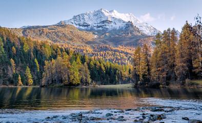 Fototapete - Amazing nature scenery. Stunning alpine Landscape. View on forest on the hill and majestic rocky mountain range with reflection on Champfer lake. Silvaplana. Switzerland, Europe. natural background