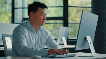 Mature Asian businessman chinese korean office worker specialist male work on computer develop project online look at camera confident smile. Portrait successful senior man business profession concept